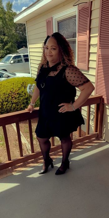 A reviewer showcasing a sleek black ensemble