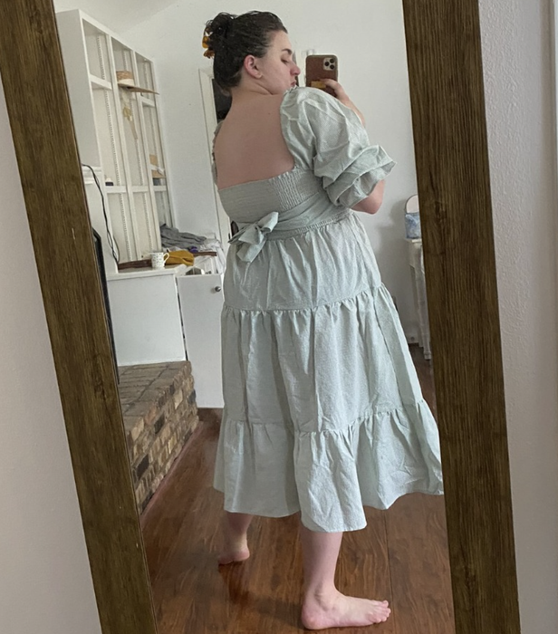A customer review photo displaying the back of the dress while they model it