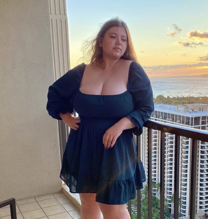 A reviewer modeling the blue dress