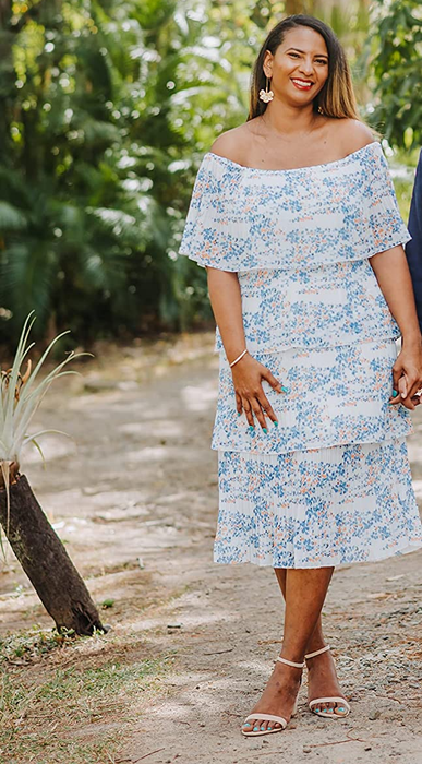 a reviewer showcasing the dress in a blue and white patterned design