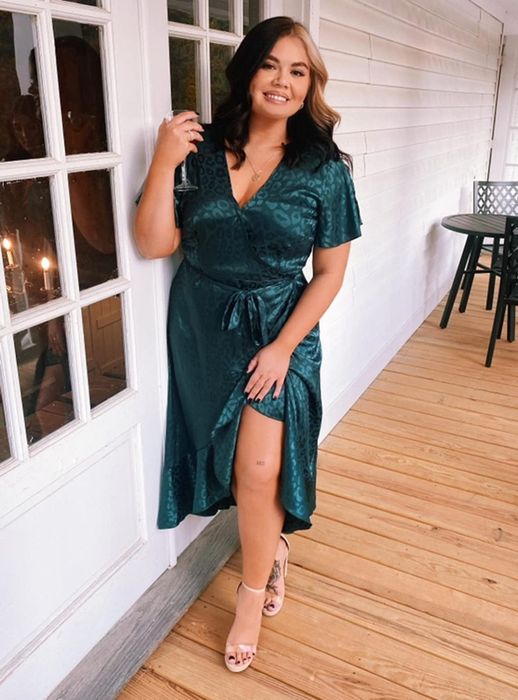 A reviewer modeling the green dress during an outdoor photoshoot, bringing the vibe to life