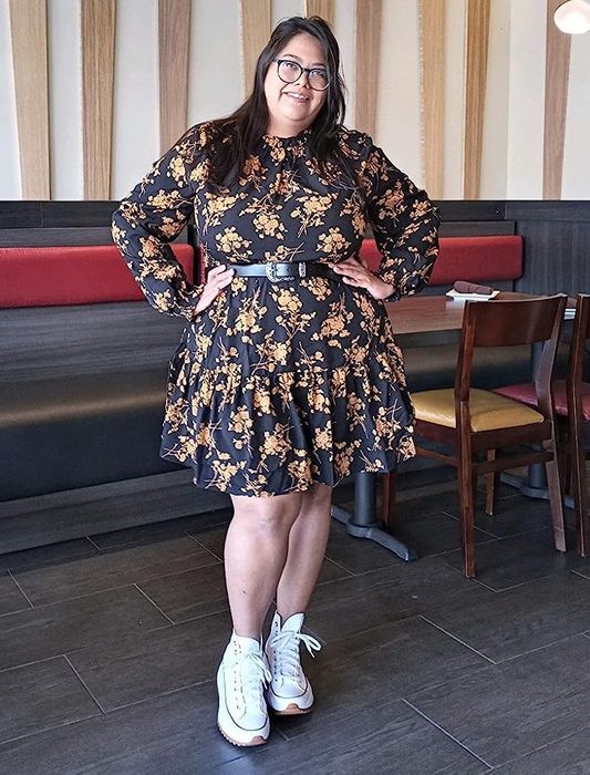 Reviewer showcasing the black and yellow floral dress
