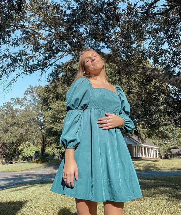 A reviewer showcasing the teal dress