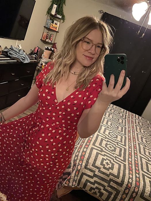 A reviewer modeling a red dress.