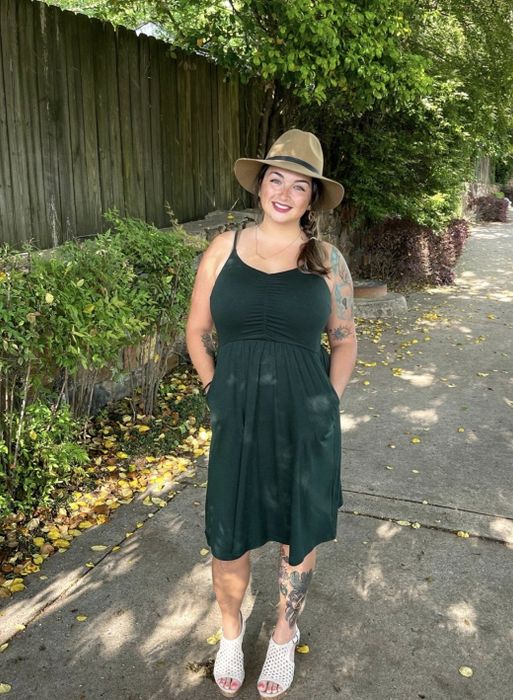A reviewer modeling the green dress