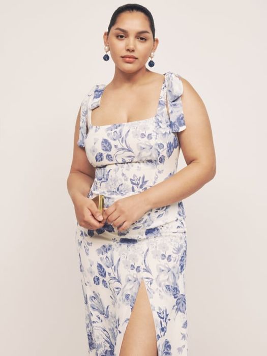 A different model in a white and blue floral version of the same dress