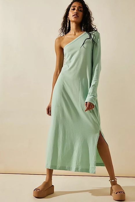 A model in a green dress, complemented by brown sandals.