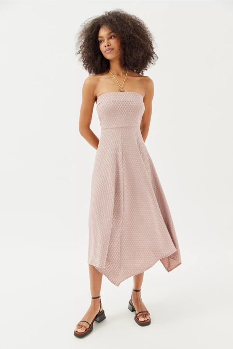 A model showing off the pink textured dress in a pose.