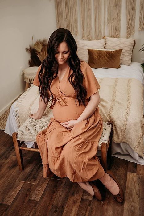 A reviewer wearing the same dress in a soft, solid light pink hue.