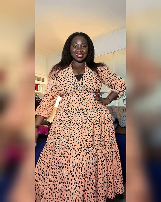 A reviewer wearing a pink dress with black polka dots.