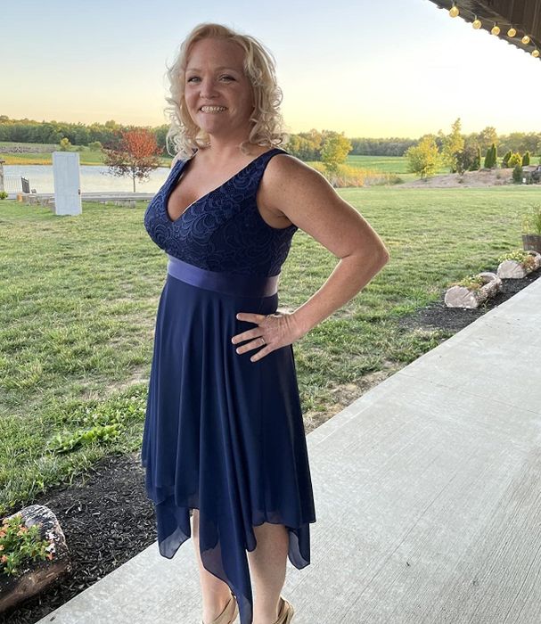 A reviewer wearing the navy blue dress