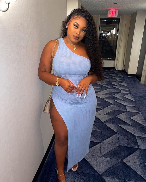 Reviewer wearing a blue one-shoulder dress
