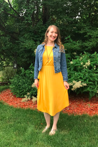 reviewer wearing the yellow dress paired with a denim jacket