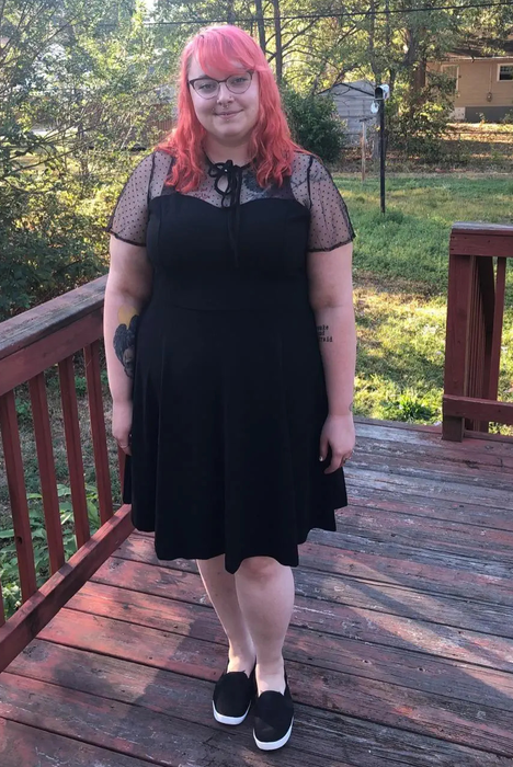 A reviewer wearing the dress in black