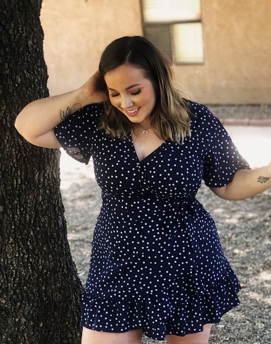 reviewer modeling the navy blue polka dot dress