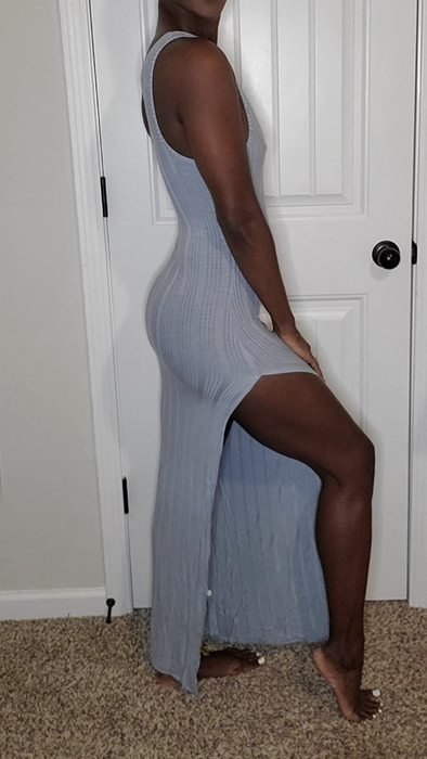 Reviewer showing off the side profile of the dress with a high slit