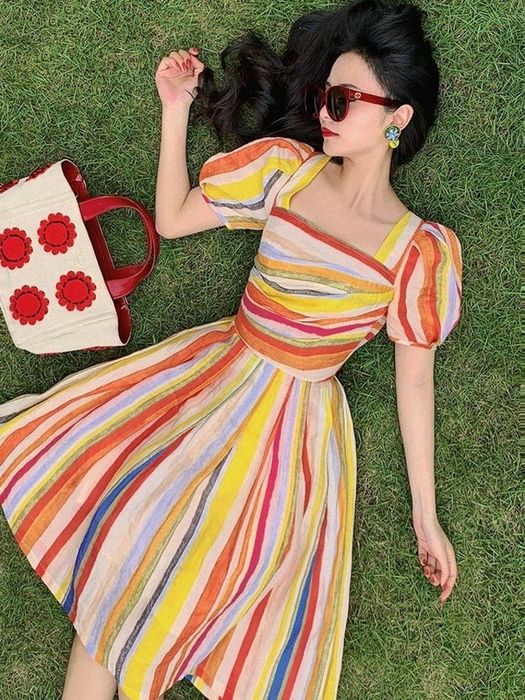 A model wears a short-sleeve, colorful striped fit-and-flare dress.