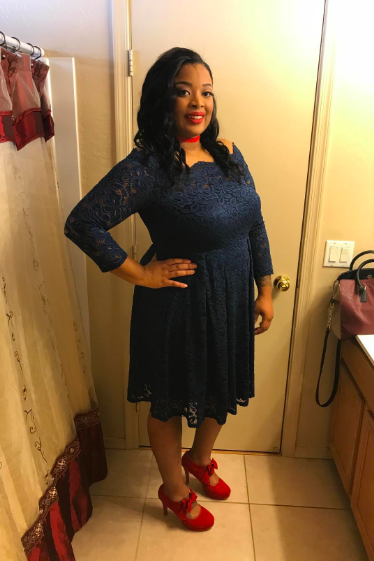 A reviewer modeling the dress in navy blue