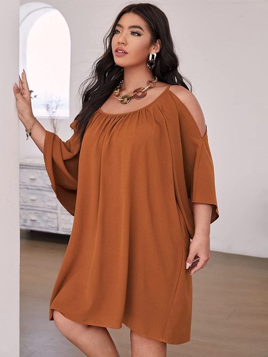 A plus-size model rocking the cold-shoulder dress in brown