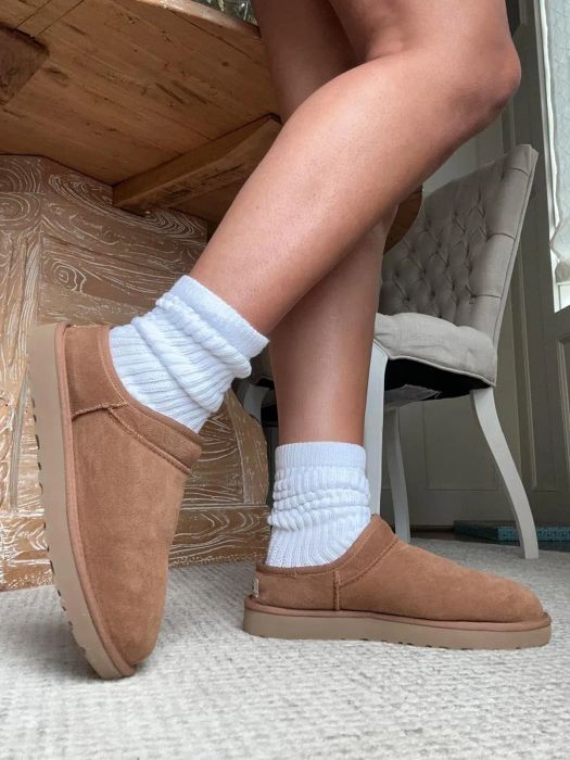 a reviewer styling the white slouch socks paired with brown Ugg booties