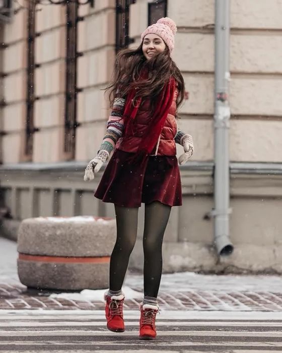 A model showcasing the black sheer-style leggings paired with a red skirt