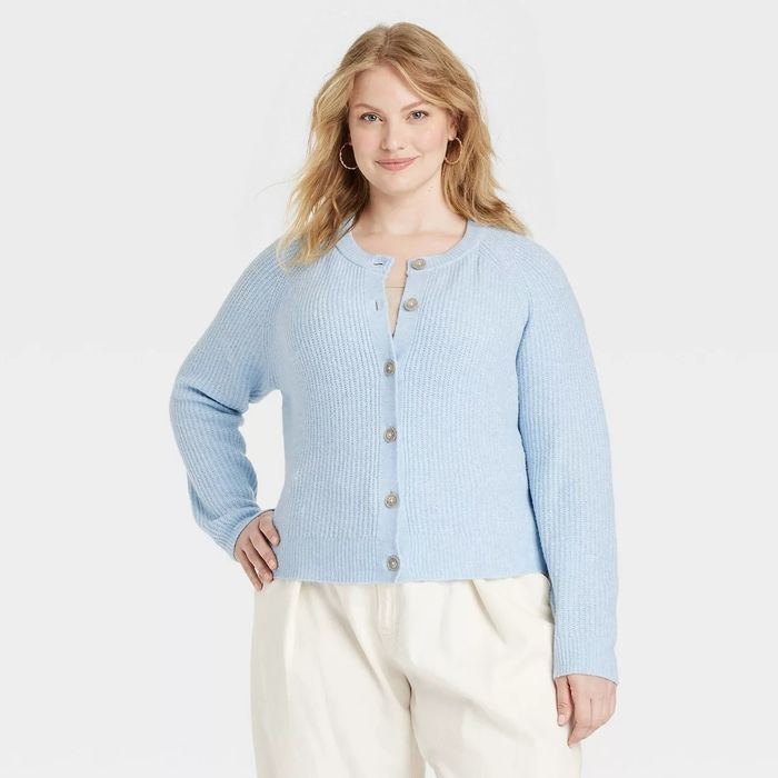A model sporting a ribbed cardigan featuring large buttons.