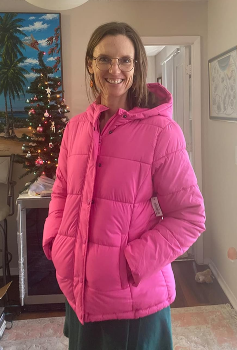 A reviewer showcasing the coat in pink