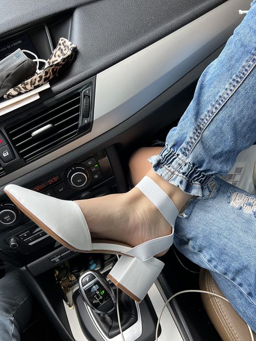 A reviewer styling white block-heel shoes paired with jeans