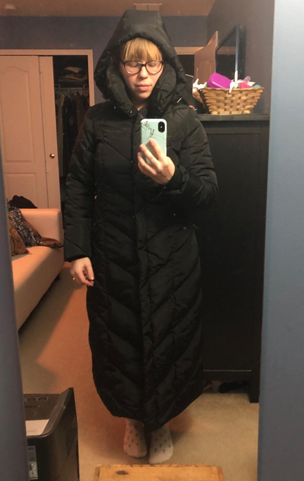 A reviewer wearing the coat with the hood up