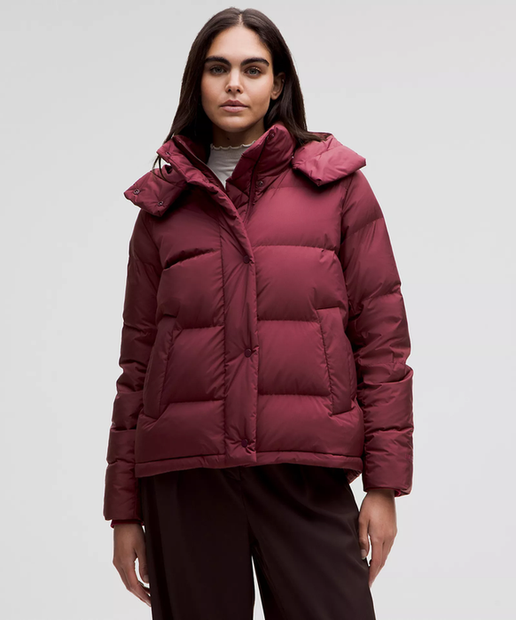 Model sporting a burgundy quilted puffer jacket with a hood, casually paired with a turtleneck, ideal for colder climates