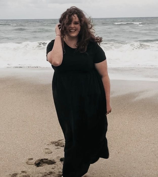 A reviewer models the dress in black, showcasing its sleek and versatile design