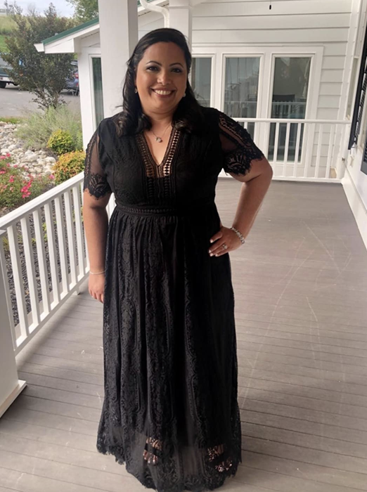 A reviewer is pictured wearing the classic black dress
