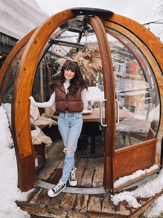 Reviewer wearing the brown puffer vest with a white long-sleeve top in a snowy setting