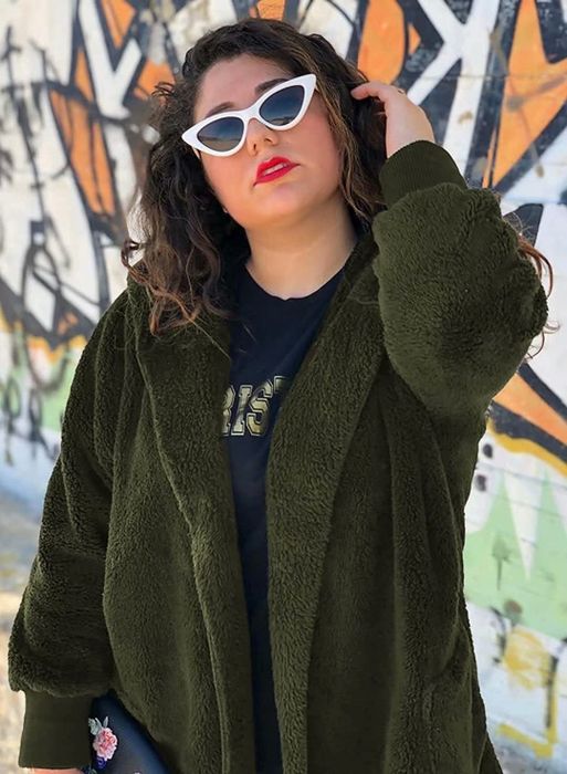 Model wearing the dark green hooded cardigan posing in front of a graffiti-covered wall