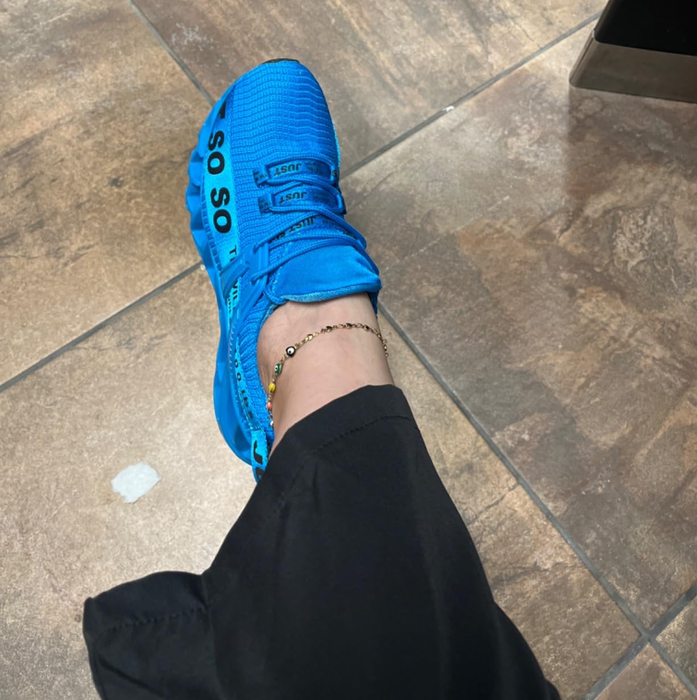 A reviewer wearing sleek blue athletic shoes