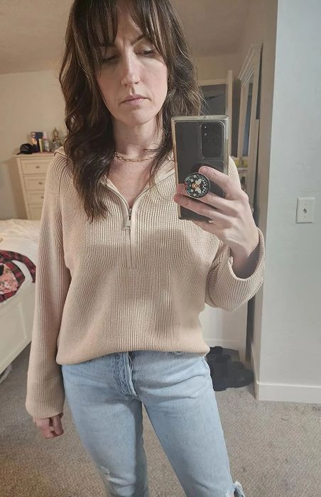 A reviewer wearing the tan sweater