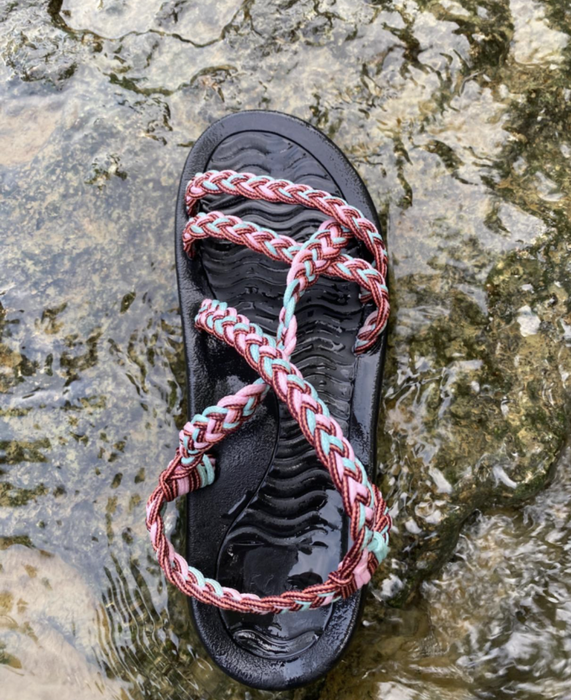 A reviewer’s photo of multicolored sandals in a river setting