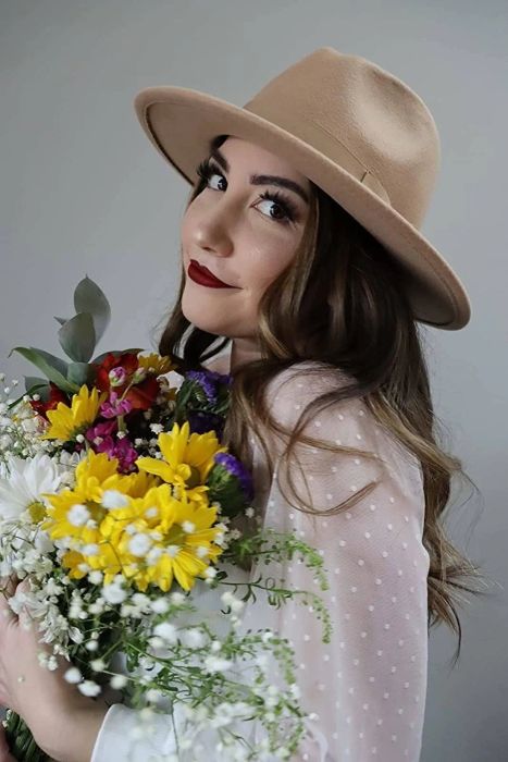 Reviewer wearing the white shirt while holding flowers