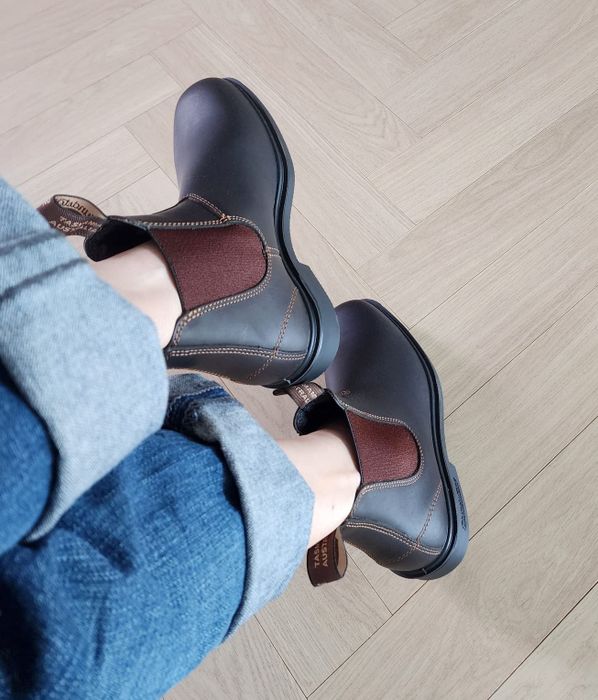 A reviewer modeling brown leather Chelsea boots