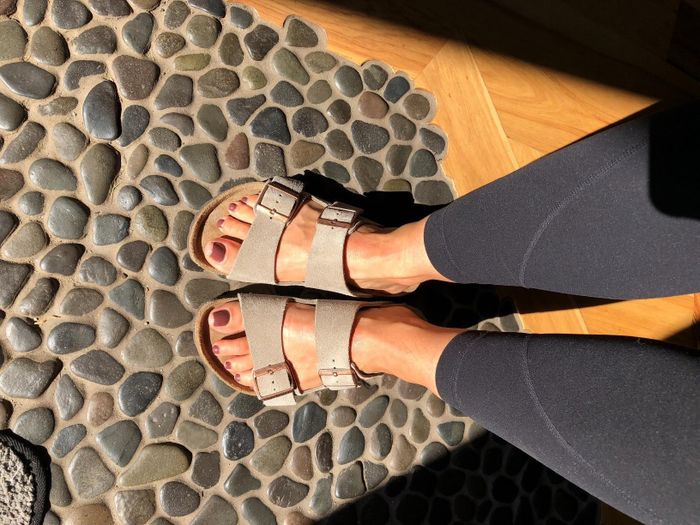 A close-up of feet standing in Birkenstock sandals