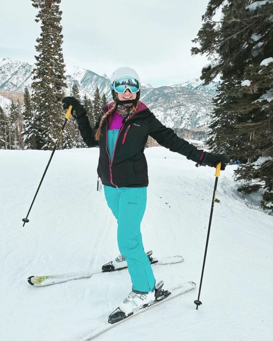 Reviewer wearing the turquoise overalls in a snowy environment