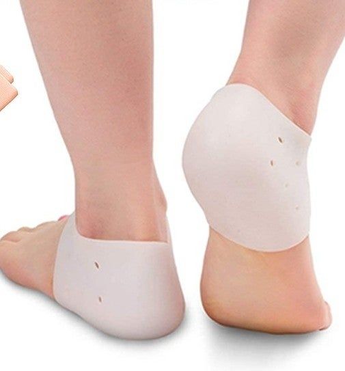 Silicone heel protectors on two feet, showing a comfortable and supportive fit for foot relief