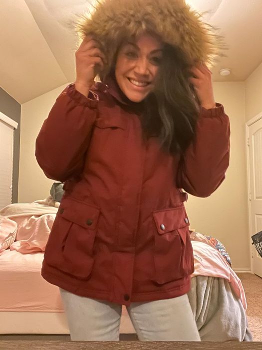 A reviewer showcasing the jacket in red.