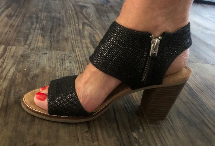 A detailed shot of a reviewer’s foot in open-toe, high-heeled sandals with a side zipper