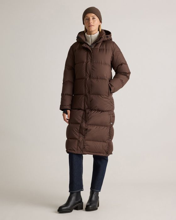 A person wearing a brown, long, puffy winter coat, jeans, boots, and a beanie, perfect for cold-weather shopping.