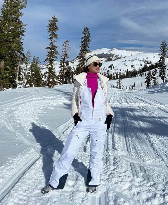 Reviewer wearing the white overalls in a snowy setting