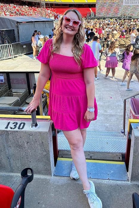 a reviewer wearing the vibrant hot pink dress to the Eras Tour