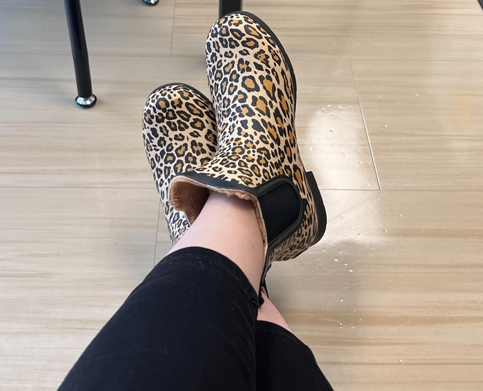 A reviewer modeling stylish leopard print boots