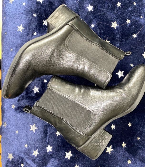 A reviewer’s photo of black Chelsea boots placed on a blue blanket