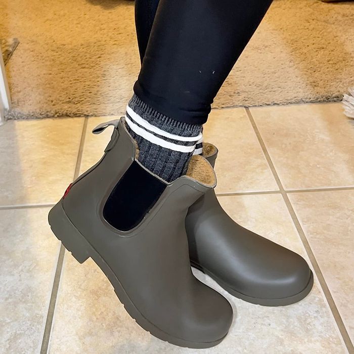 A reviewer modeling green waterproof Chelsea boots